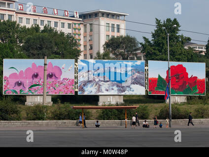 Corea del Nord persone in attesa per il bus sotto alcuni cartelloni di propaganda con il monte Paektu, Provincia di Pyongan, Pyongyang, Corea del Nord Foto Stock