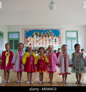 Corea del Nord le ragazze che cantano durante una lezione di classe in una scuola primaria, Sud Pyongan Provincia, Chongsan-ri Cooperativa, Corea del Nord Foto Stock