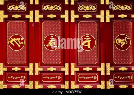Sportello cinese in rosso e oro con lacca Feng Shui simboli al di fuori di un tempio buddista di Geylang, Singapore Foto Stock