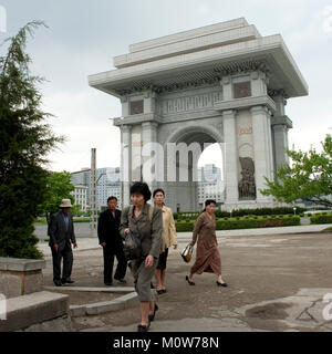 Corea del Nord persone che passano di fronte all'arco di trimuph, Provincia di Pyongan, Pyongyang, Corea del Nord Foto Stock