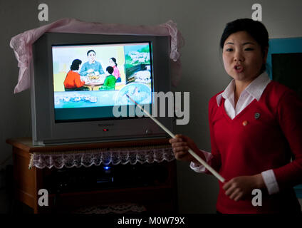 Nord coreano insegnante in una classe di fronte a un televisore, Sud Pyongan Provincia, Chongsan-ri Cooperativa, Corea del Nord Foto Stock