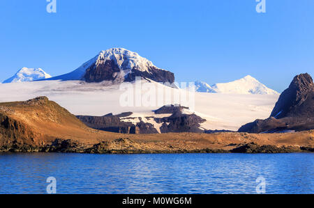 Costa ricoperta con un sacco di piccoli pinguini Gentoo e neve cime delle montagne, Barrientos isola, a sud le isole Shetland, penisola Antartica Foto Stock