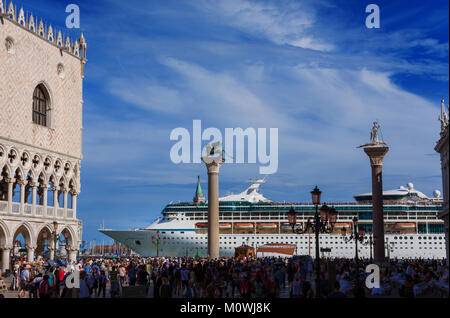 I turisti guardare la gigantesca nave da crociera di fronte a Piazza San Marco. Un grosso problema per la salvaguardia di Venezia ambiente fragile e la città storica di h Foto Stock