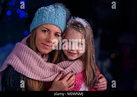 Mamma e figlia in una sera d'inverno al di fuori Foto Stock