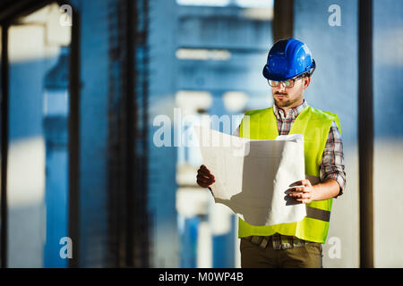 Immagine del sito in costruzione ingegnere guardando al plan Foto Stock