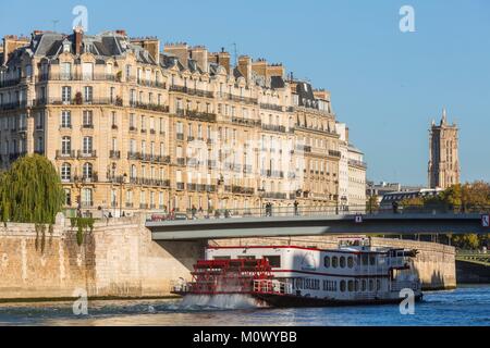 Francia,Parigi,zona elencata come patrimonio mondiale dall UNESCO,Quai de la Tournelle,una barca in Aube passa di fronte al Ile de la Cite e il Tour Saint Jacques Foto Stock
