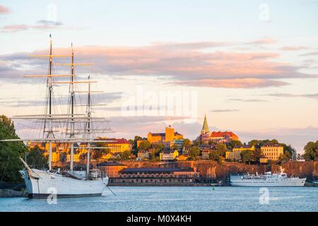 La Svezia,Stoccolma,isola di Skeppsholmen con la tre-masted af Chapman del 1888 trasformata nel 1949 in un ostello della gioventù e il quartiere di Sodermalm in background Foto Stock