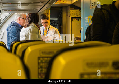 Ryanair equipaggio di cabina Controllo delle carte di imbarco di passeggeri a bordo del velivolo, aeroporto di Dublino, Irlanda Foto Stock