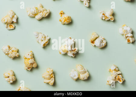 Il popcorn nel bicchiere di carta su sfondo verde. Foto Stock