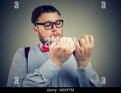 Giovane uomo serio con disturbo ossessivo compulsivo esplorando la pulizia delle mani. Foto Stock