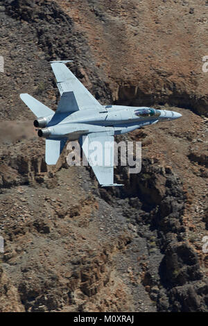 Marina degli Stati Uniti F/A-18C, Hornet, jet fighter Bomber, volare ad alta velocità e basso livello attraverso un canyon del deserto. Foto Stock