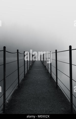 Foto in bianco e nero di Ponte a Sasamat Lago Trail, Port Moody, Vancouver, British Columbia, Canada su un nebbioso giorno con misteriose sensazioni di esso Foto Stock