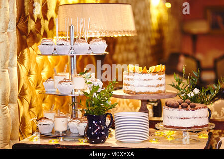 Candy bar. La tabella con i dolci - tortine, caramelle, torte dessert. Candybar di nozze Foto Stock