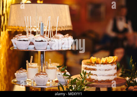 Candy bar. La tabella con i dolci - tortine, caramelle, torte dessert. Candybar di nozze Foto Stock