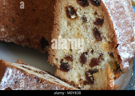 Pan di Spagna con uvetta con crosta dorata spolverato con zucchero a velo vicino a Foto Stock