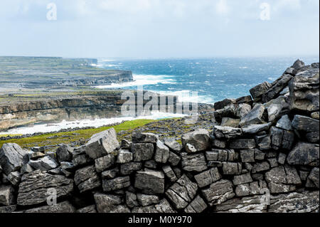 Paesaggio costiero con scogliere ventoso e tempestoso mare sulle isole Aran, un gruppo di tre isole situate in corrispondenza della bocca della Baia di Galway, sul wes Foto Stock
