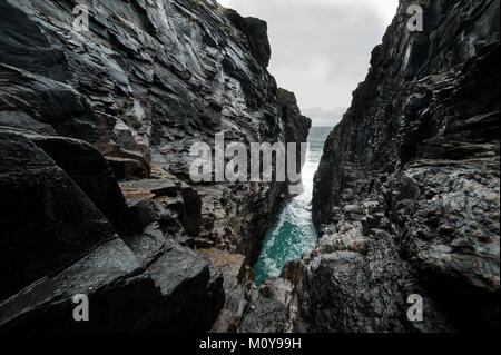 Hells foro, una caverna sotterranea in cui la marea Atlantico esplode con una forza enorme, a Malin Head, Donegal, Irlanda. Foto Stock