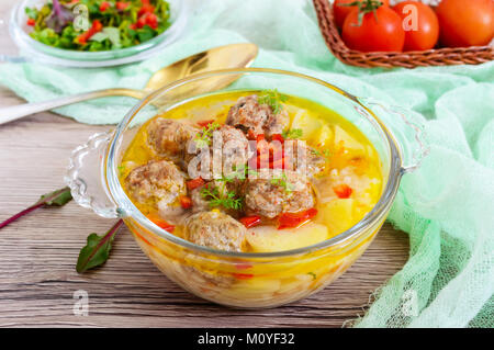 Una zuppa di riso con polpettine di carne e verdure in un vetro trasparente ciotola. Close up Foto Stock