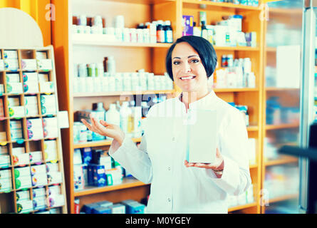 Ritratto di Allegro maturare il farmacista donna con biologicamente attivo integratore dietetico package Foto Stock