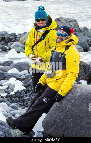 Due professionale guide di montagna chat sulla spiaggia rocciosa; Half Moon Island; Antartide Foto Stock