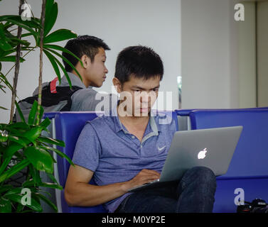 A Saigon, Vietnam - Mar 28, 2017. Un giovane uomo che lavora con un MacBook al gate di imbarco dell'Aeroporto Internazionale di Tan Son Nhat a Saigon, Vietnam. Foto Stock