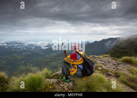 Gondar, Etiopia, Ottobre 4th, 2014: ranger di montagna con una pistola a riposo e si affaccia su una valle Simien Mountains Foto Stock