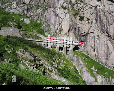 Express San Gottardo treno su Teufelsbruecke nei pressi di Andermatt in Svizzera, Devil's ponte ferroviario e tunnel, alpi svizzere, alpine montagne rocciose terra Foto Stock