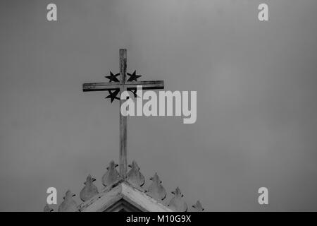 Immagine in bianco e nero di close up metallo santa croce o crocifisso sulla parte superiore della chiesa bianca. (Fuoco selettivo) Foto Stock