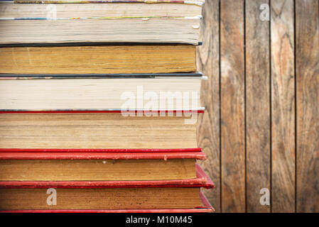 Pila di vecchi libri vintage, tavole di legno sfondo Foto Stock