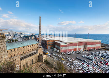 Savona, Italia - 2 Dicembre 2016: paesaggio industriale sulla riva del mare con hangar, magazzini, automobili e un camino in Savona, Italia. Spese di spedizione, commercio Foto Stock