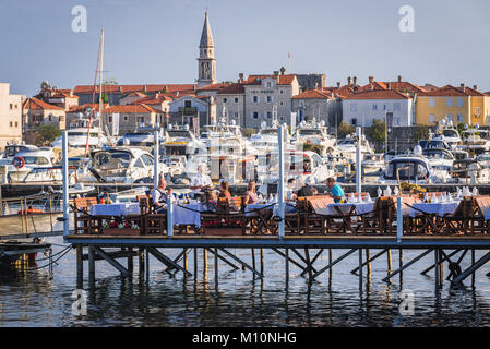 Ristorante su un molo con vista sulla città vecchia di Budva città sul mare Adriatico costa in Montenegro Foto Stock