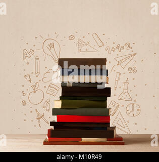 Una pila di libri sul tavolo con la scuola disegnata a mano doodle bozzetti e simboli Foto Stock
