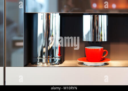 Red mug sorge in una macchina per il caffè Foto Stock