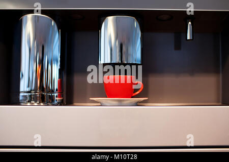 Red mug sorge in una macchina per il caffè Foto Stock