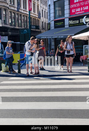 Bruxelles, Belgio. Coppia giovane kissing mentre si è in attesa di attraversare la strada Foto Stock