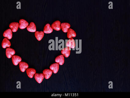 Cuore rosso fatta di piccoli cuori su sfondo scuro, closeup, concetto di giorno di San Valentino Foto Stock