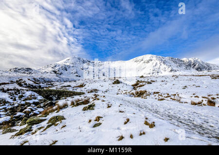 Bella scena invernale del ponte in pietra sopra la beck sulla cicatrice Walna road tra Coniston e la Duddon Valley con la coperta di neve Dow Crag rid Foto Stock