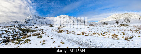 Stupenda vista panoramica vista invernale di Dow Crag e Coniston vecchio uomo preso dalla cicatrice Walna road dal ponte di pietra che attraversa il beck Foto Stock