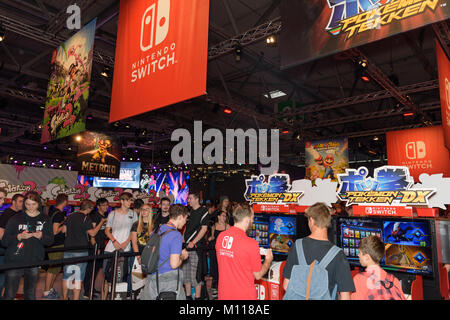 Colonia, Germania - 24 agosto 2017: i visitatori della fiera la riproduzione di giochi e in attesa presso lo stand dell'azienda Nintendo in occasione di gamescom 2017. Foto Stock