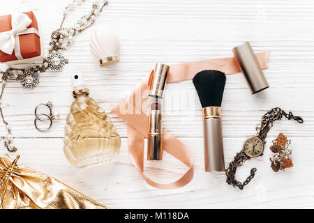 Luxury gioielli costosi e make up essentials e profumo flat laici bianco su tavola in legno rustico con spazio per il testo in morbida luce mattutina. fashion b Foto Stock