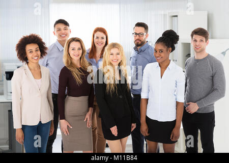 Certi giovani sorridente multi etnico la gente di affari in ufficio Foto Stock