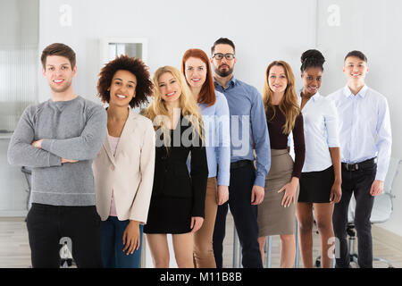 Certi giovani sorridente multi etnico la gente di affari in ufficio Foto Stock