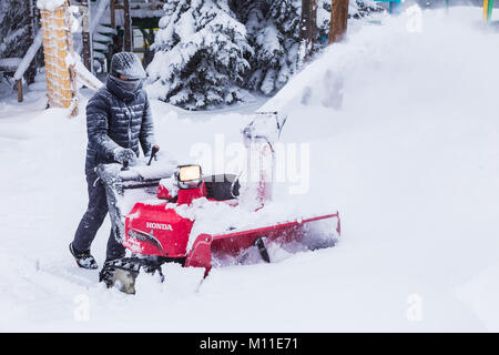 Hokkaido, Giappone - 28 dicembre 2017 - l'uomo non identificato di usare la sua red rimozione neve macchina al percorso chiaro modo in un parco in Hokkaido, Giappone il 28 dicembre Foto Stock