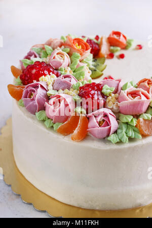 Festosa torta con crema di fiori e di frutti su uno sfondo luminoso Foto  stock - Alamy