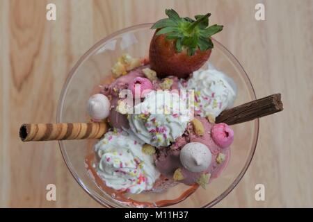 Sopra la testa vista la fotografia di una deliziosa estate tempo gelato alla fragola gelato in un piatto di vetro con frutta meringa panna e cioccolato Foto Stock