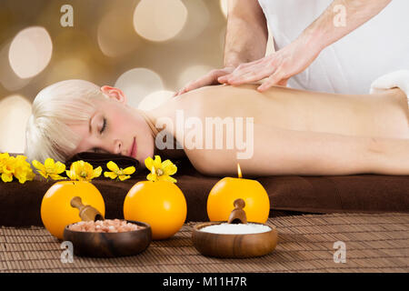 Close-up di un terapeuta maschio dando massaggio alla schiena per giovani femmine Client In Spa Foto Stock