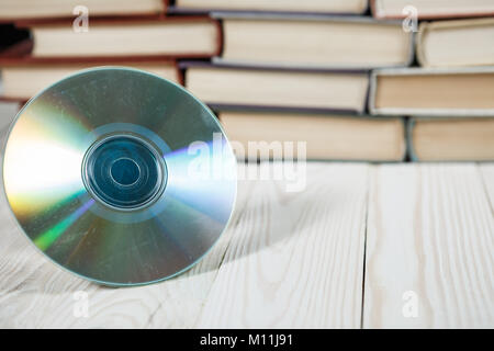 Pila di vecchi libri impilati uno sull'altro con un compact disc, il concetto di audiolibri Foto Stock