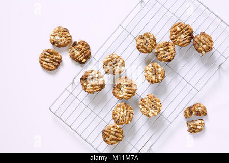 Data casalinga, mandorla e chocolate chip fragranti biscotti raffreddamento su una griglia di raffreddamento. Foto Stock