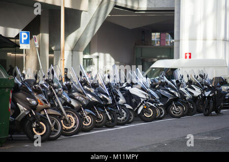 Genova, Italia - 18 Gennaio 2018: moderni scooter stand in una fila su urban parking lot, foto con messa a fuoco selettiva Foto Stock