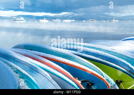 Snowy scena con coperta di neve paddle boards allineate in una fila. Questa foto è stata scattata a Zepher Cove nel South Lake Tahoe, NV? Foto Stock